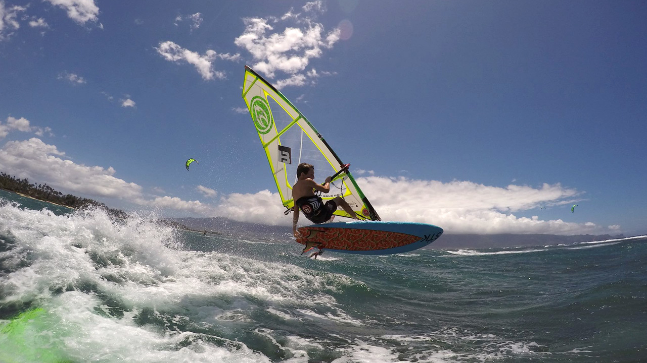 Dax Barker jumps over a wave on Maui